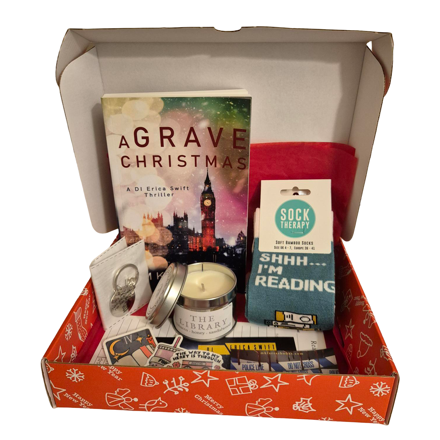 Christmas book box containing signed paperback, candle, and socks.