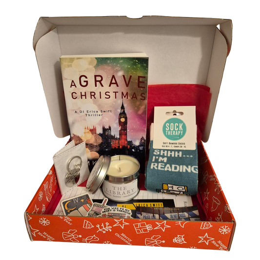 Christmas book box containing signed paperback, candle, and socks.